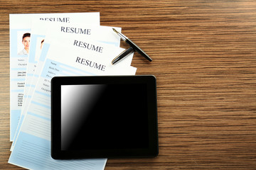 Employer workplace with tablet and resumes