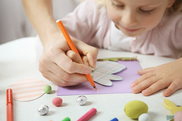 Mother and little girl painting handmade Easter card