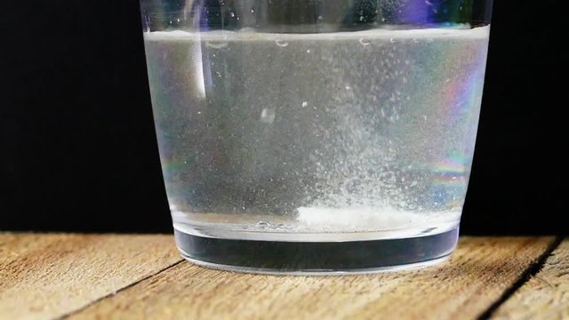 Water inside glass with vitamin C tablet  bubbles