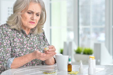 Sick elderly woman with medicines