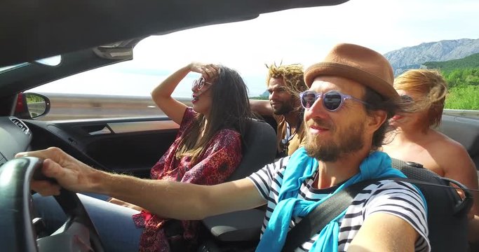 Bearded hipster man with hat listening to music with friends in convertible