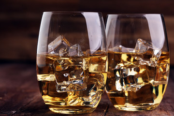 glass of whiskey with ice on a wooden