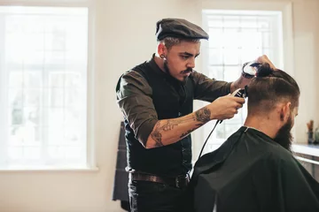 Crédence de cuisine en verre imprimé Salon de coiffure Hairstylist cutting hair of customer at barber shop