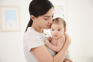 Happy mother with cute little baby at home