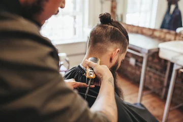 Crédence de cuisine en verre imprimé Salon de coiffure Man getting haircut by barber at salon