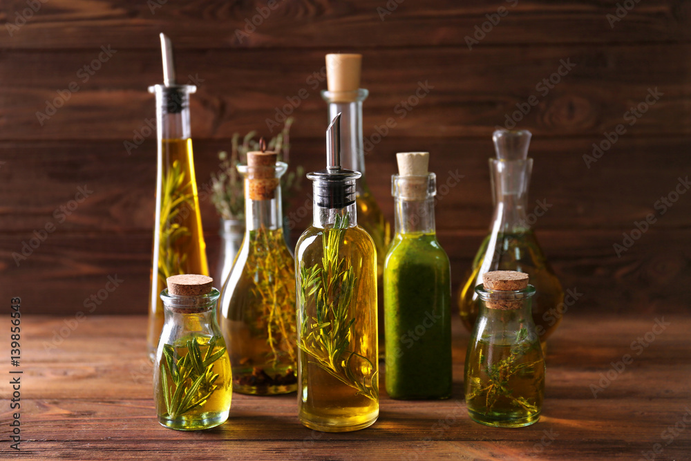 Wall mural Composition of bottles with oil on wooden background - Wall murals