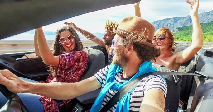 Bearded hipster man listening to music with friends in convertible, graded