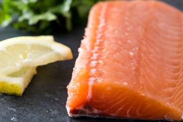 Raw salmon fillet on black slate
