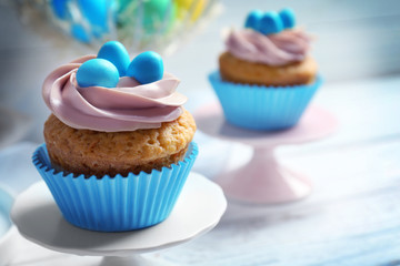 Cake stand with delicious Easter cupcake on white wooden table