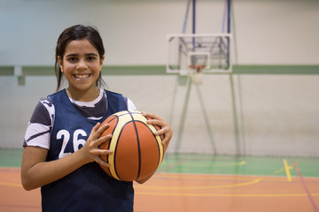 Mixed race girl holding basketball