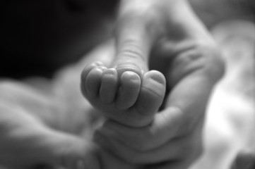 newborn  feet in mother's hands