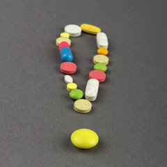 Exclamation point created from colored pills. Medical concept