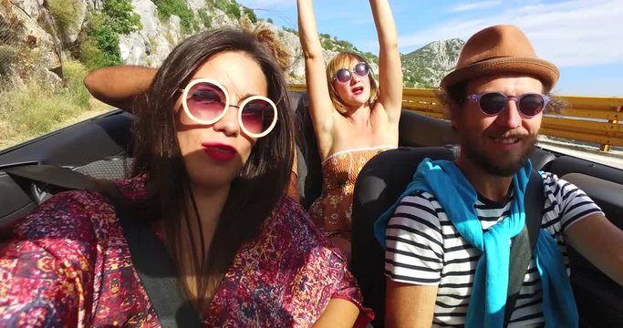 Attractive young people enjoying driving in convertible 