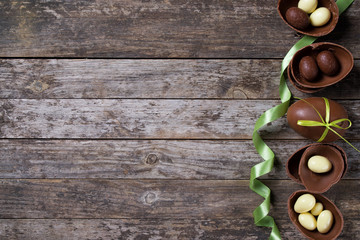 Chocolate Easter eggs on rustic wooden background, top view