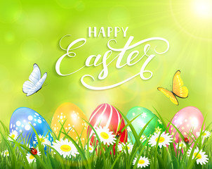 Happy Easter on green background and eggs on grass