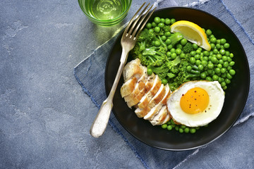 Healthy dinner bowl with green vegetables,roasted chicken and fried egg.Top view.