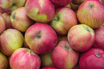 Background of apples. Round apples lie on the surface. Outdoors.