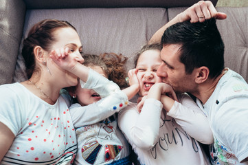 Happy family lying on the couch and laughing