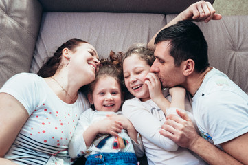 Happy family lying on the couch and laughing