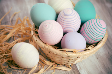 Easter eggs in a basket on wooden boards