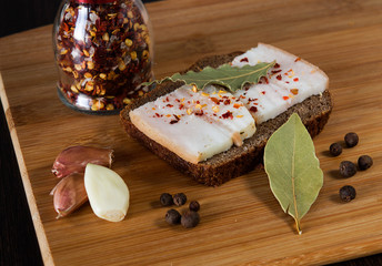 Lard with bread, garlic and spices on the board