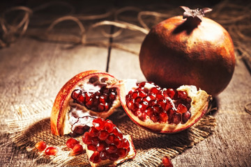 Fresh peeled pomegranates with ruby red beans on old wooden table