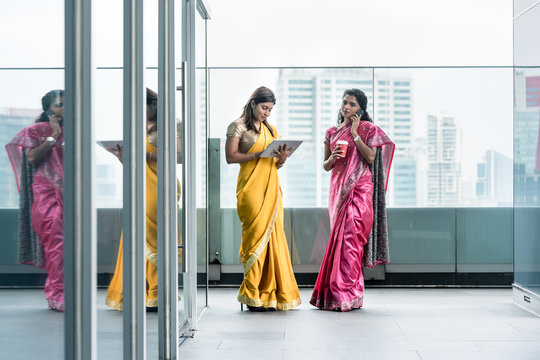 Indian women using modern technology for communication during the break