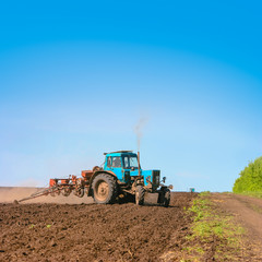 Tractor cultivating field at spring. Russian agriculture