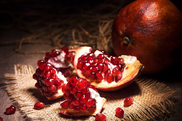 Fresh peeled pomegranates with ruby red beans on old wooden table