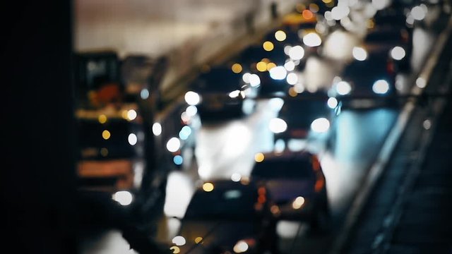 Car lights are seen in a night scene with urban traffic congestion