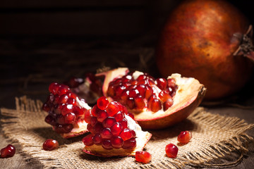 Fresh peeled pomegranates with ruby red beans on old wooden table