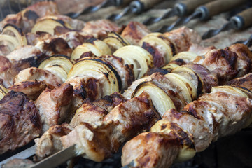 Cooking juicy meat with onions on the coals