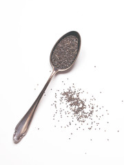 Old silver vintage spoon with chia seeds on white background. Healthy food ingredient. Flat lay. Top view.