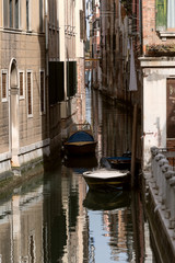 Obraz na płótnie Canvas Narrow channel with two boats in Venice