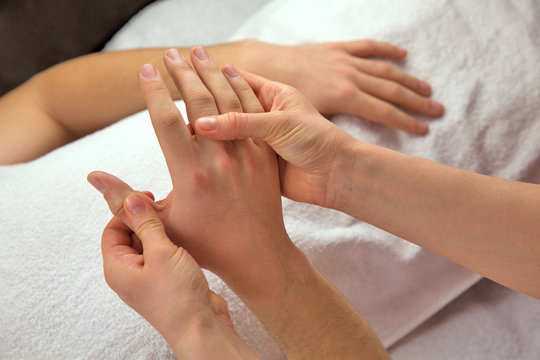 Hand massage with white towel, spa salon