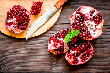 sliced pomegranate on wooden background top view