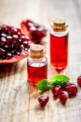 sliced pomegranate and extract in glass on wooden background