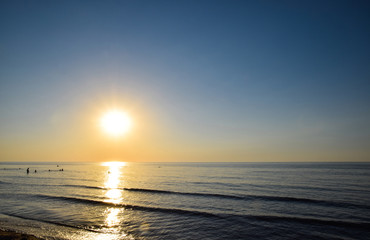 Sea sunset. People bathe in the evening at sunset in the sea.