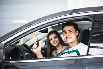 Young couple with keys to new car