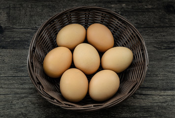 Chicken eggs in brown basket.
