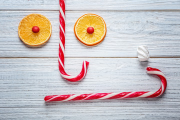 Composition with Christmas candy canes on white wooden table