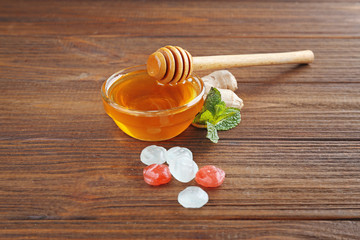 Cough drops with honey on wooden background