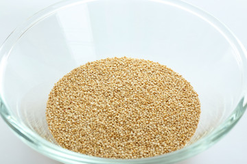 Organic quinoa seeds in glass bowl, closeup