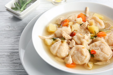White plate with delicious chicken and dumplings on light background