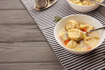 Portions of delicious chicken and dumplings on dining table