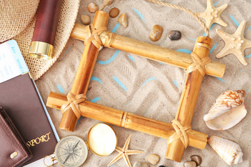 Travel concept. Composition of marine symbols and bamboo frame on sand background
