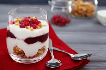Delicious natural yogurt parfait with berries and granola on wooden background