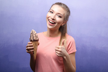 Beautiful young woman with ice cream on color background