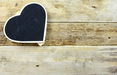 Rustic image of heart shaped chalkboard that is blank with copy space on a wood plank background.