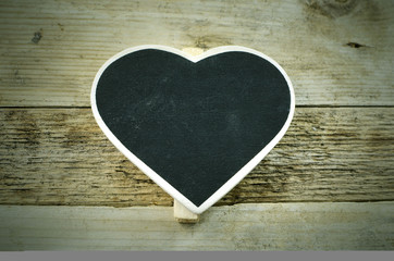 Rustic image of heart shaped chalkboard that is blank with copy space on a wood plank background. Vintage filter applied.